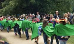 Die Schulkinder marschieren beim Festumzug mit dem "grünen Band" durch den Schlosspark.